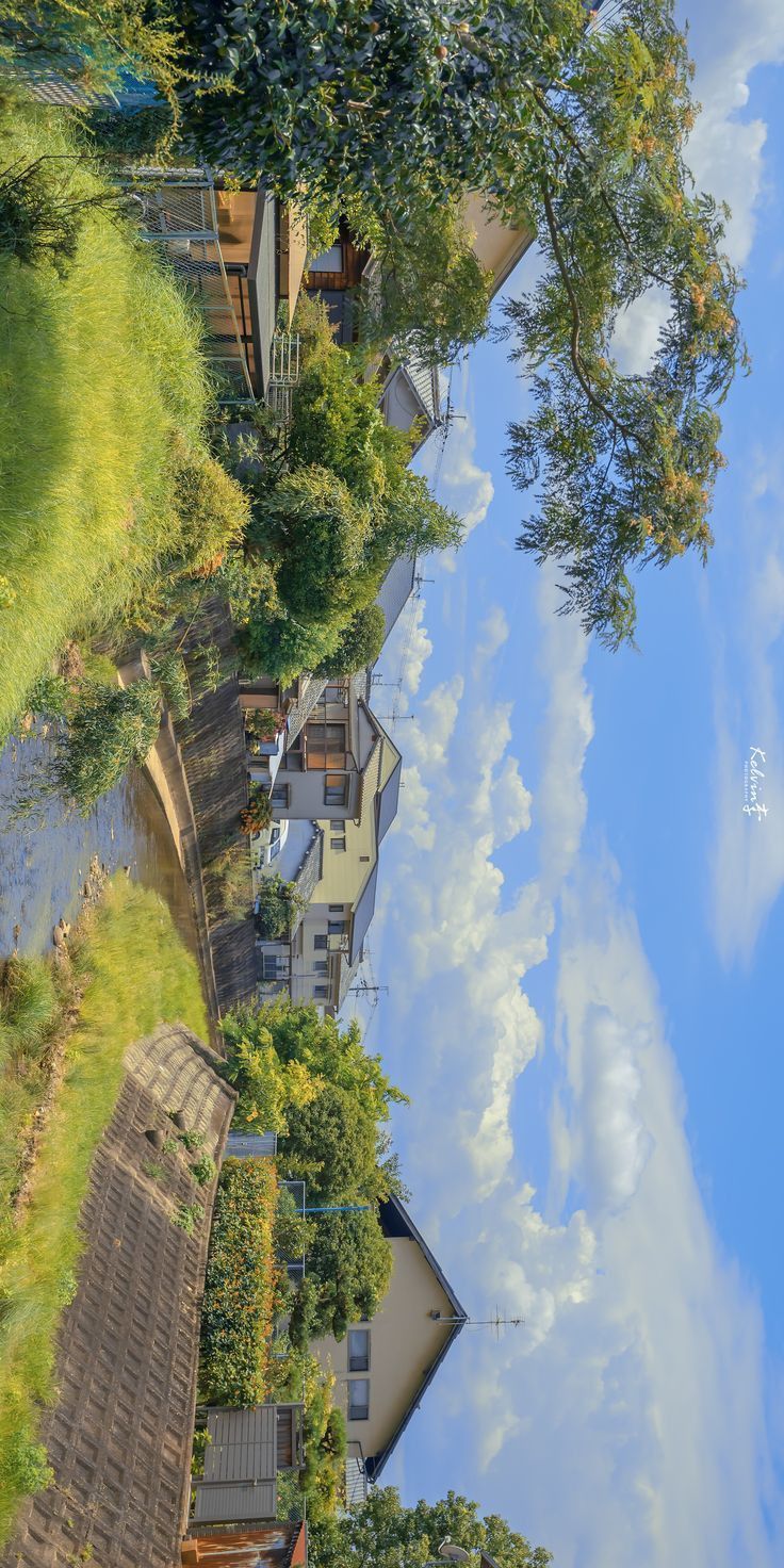 the reflection of houses in the water is very colorful and artistically beautiful, with green trees on both sides