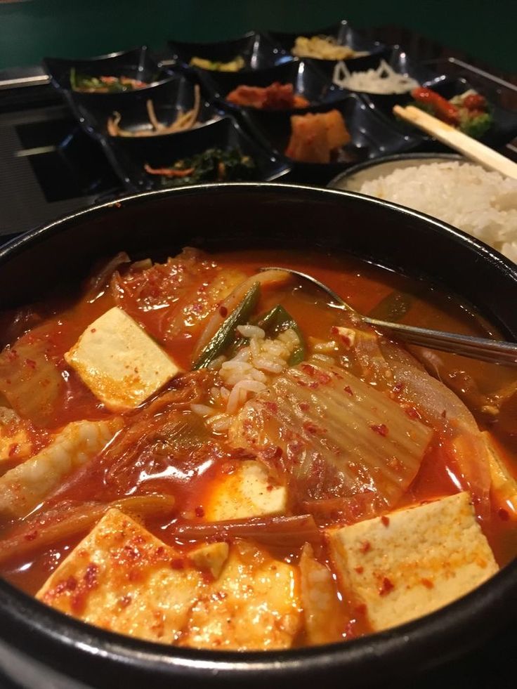 a close up of a bowl of food with chopsticks