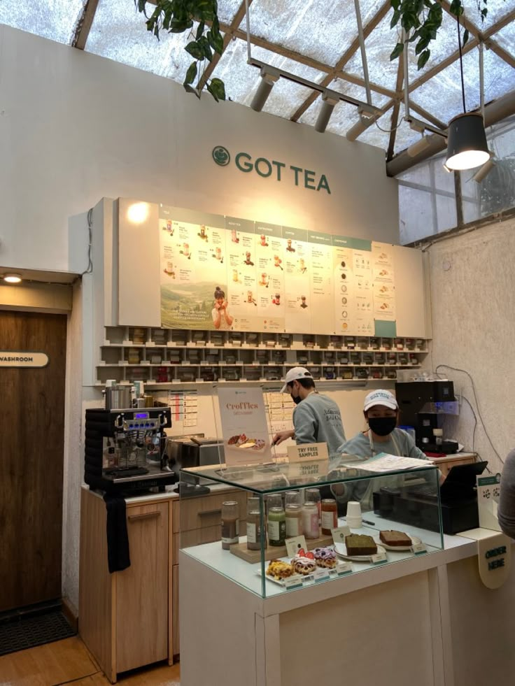 two people working behind the counter at a coffee shop