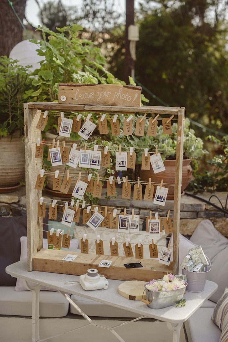 a table topped with lots of cards next to potted plants and hanging from strings