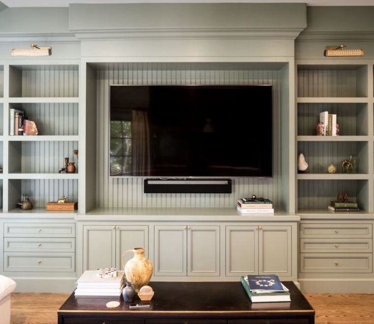 a living room with built in bookshelves and a flat screen tv