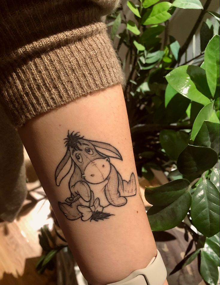 a tattoo on the arm of a person with a rabbit in it's lap