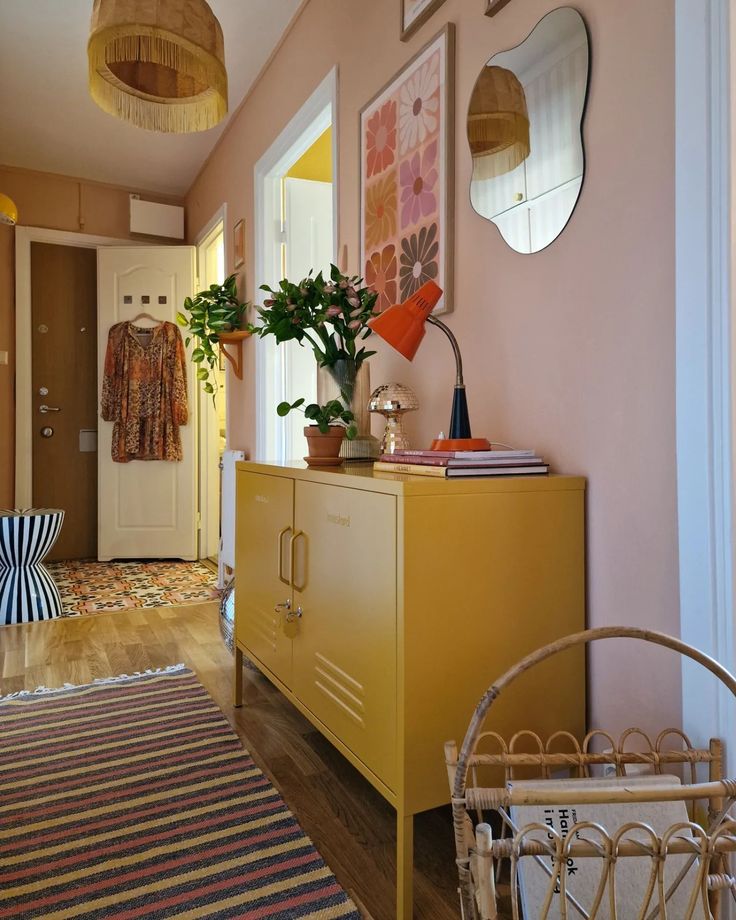 a yellow cabinet sitting in the middle of a living room next to a rug and lamp