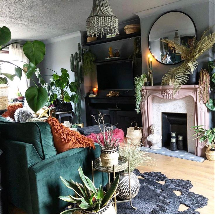 a living room filled with furniture and lots of plants on top of the fireplace mantel