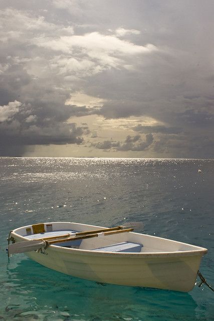 a small white boat floating on top of the ocean