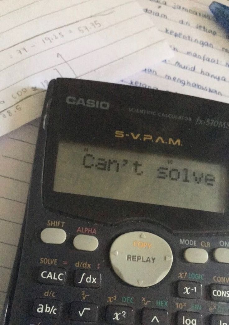 a calculator sitting on top of a pile of papers next to a pen