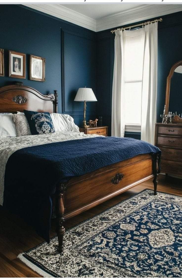 a bedroom with dark blue walls and wooden furniture, including a large bed in the middle