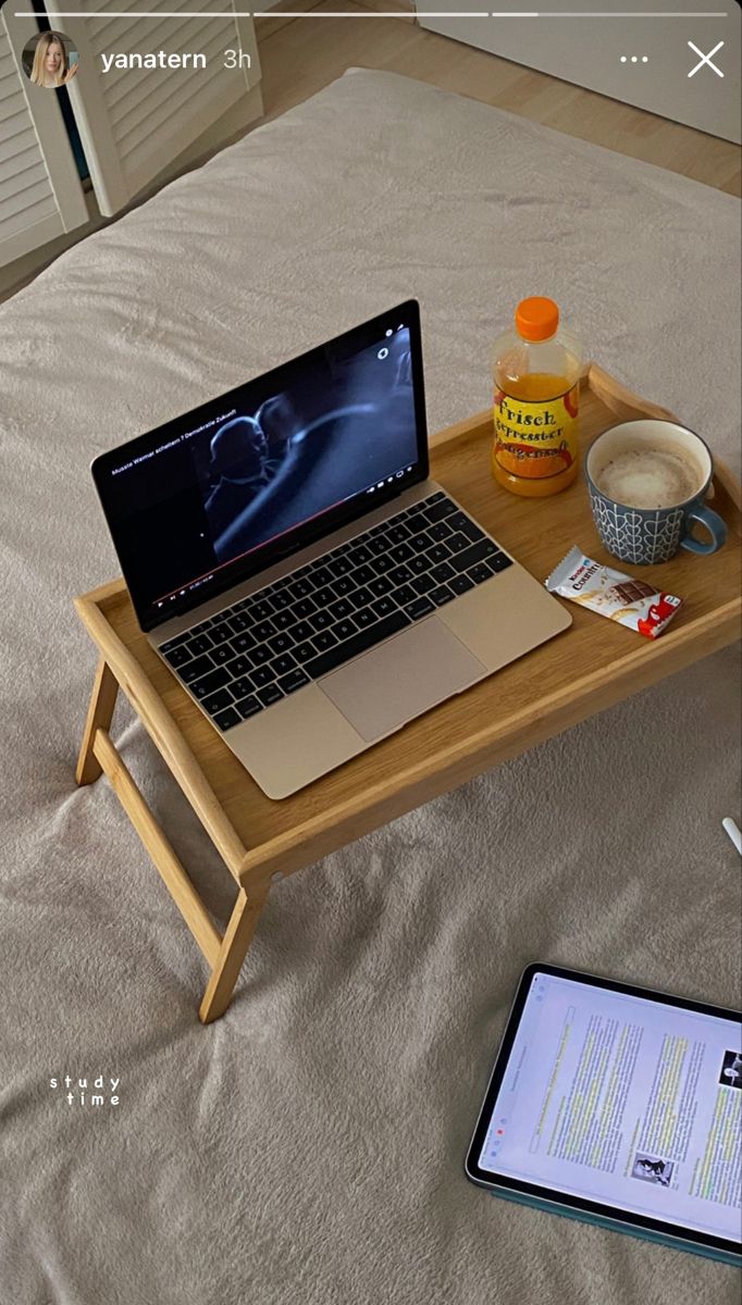 an open laptop computer sitting on top of a wooden table next to a tablet pc