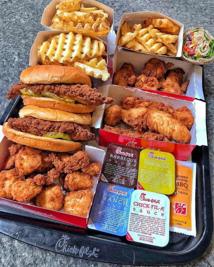 chicken sandwiches and waffles are sitting on a tray next to other food items