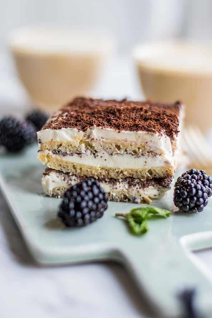 a piece of cake sitting on top of a plate next to berries and coffee cups