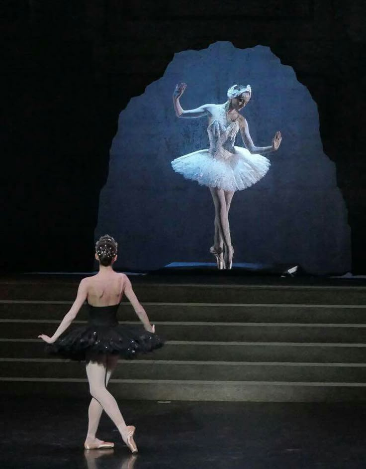 two ballerinas in tutu and leotards on stage, one is dancing