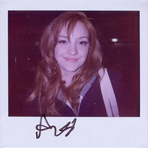 a woman with long hair is smiling at the camera