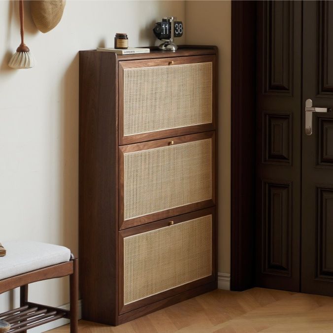 a brown cabinet sitting next to a white chair in a room with wooden flooring