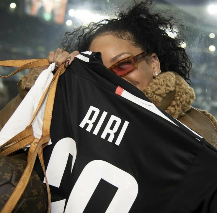 a woman holding up a jersey with the number 10 on it in front of her face