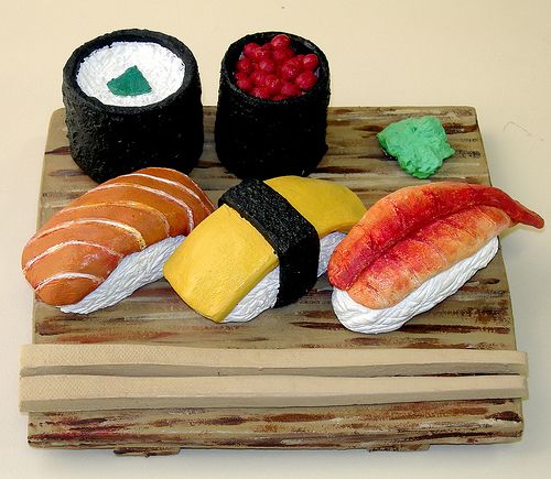 some sushi is sitting on a wooden board