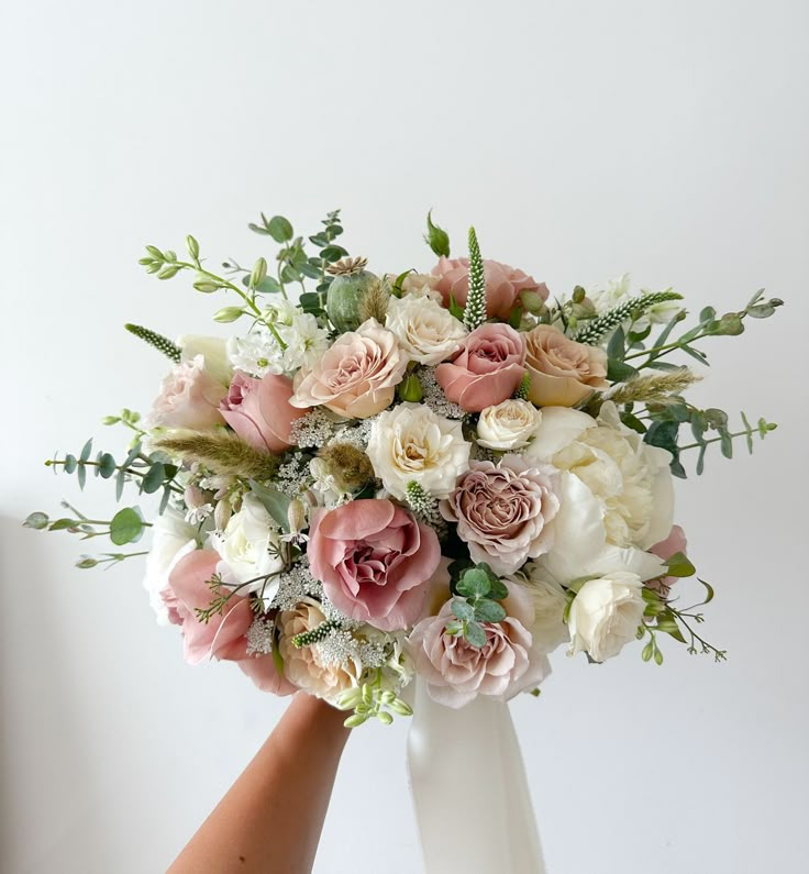 a bouquet of flowers is being held by someone's hand