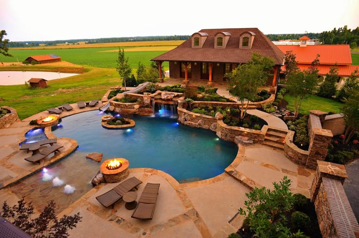 an aerial view of a backyard with a pool and fire pit in the foreground