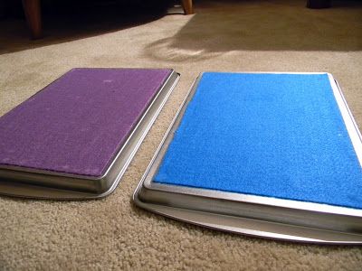 two purple and blue books laying on the floor next to each other in front of a couch