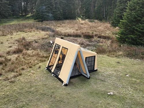 a tent in the middle of a grassy field