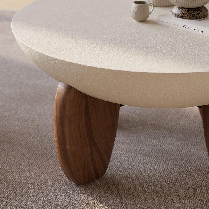 a coffee table with two cups on it and a book sitting on top of it