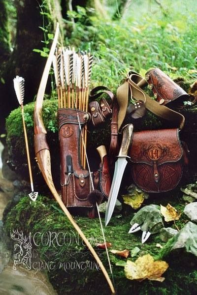 an assortment of hunting gear sitting on top of a moss covered ground