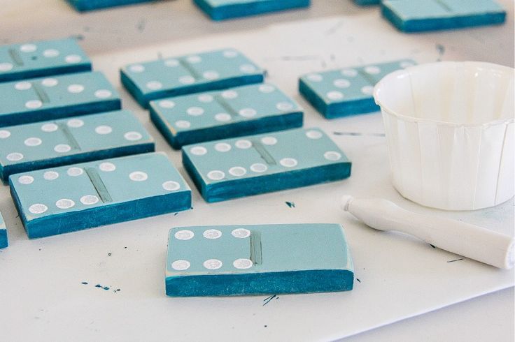 some blue and white dominos sitting on top of a table next to a cup