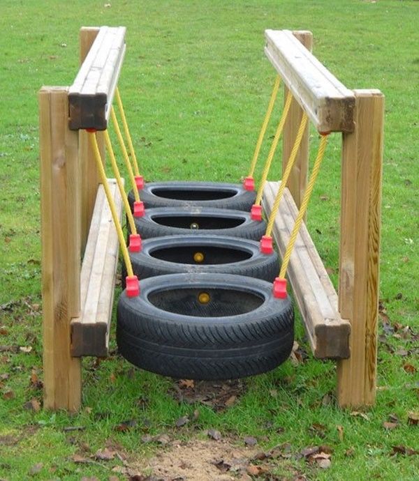 four tire swings in the middle of a grassy field