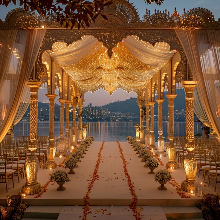 an outdoor wedding set up with candles and flower petals on the aisle, overlooking water