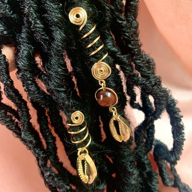 From the 'For The Goddess In You' Collection👑 Handcrafted with intention✨ Made with the best tarnish resistant wire, tigers eye bead and gold cowrie shell charm Adorns any medium sized locs, braids, and twists sized 7-9mm. Wire is 18g thickness- Firm but adjustable To get the most out of your jewelry take off your cuff before washing your hair 💦 *I do not accept returns but please don't hesitate to contact if there are any issues and I'd be more than happy to help💕 Peace & Love -Liz🤎 Locs With Gold Cuffs, Gold Braid Accessories, Faux Locs With Shells, Gold Hair Jewelry For Braids, Loc Charms Dreadlock Accessories, Locs With Gold Accessories, Hair Charms For Locs, Locs Jewelry Accessories, Braids With Gold Cuffs