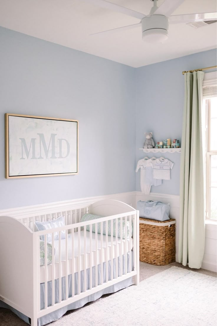 a baby's room with blue walls and white furniture