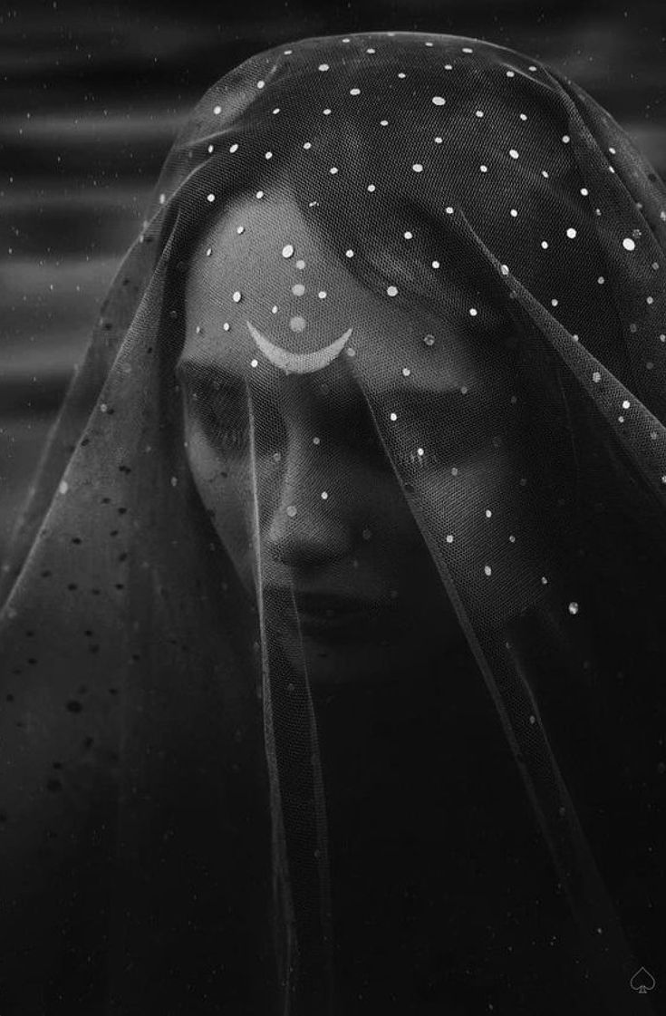 a black and white photo of a woman's face with rain drops on her veil