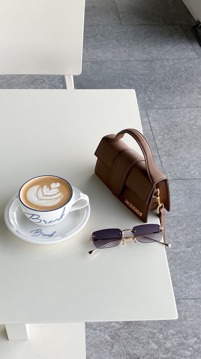 a cappuccino and sunglasses on a white table