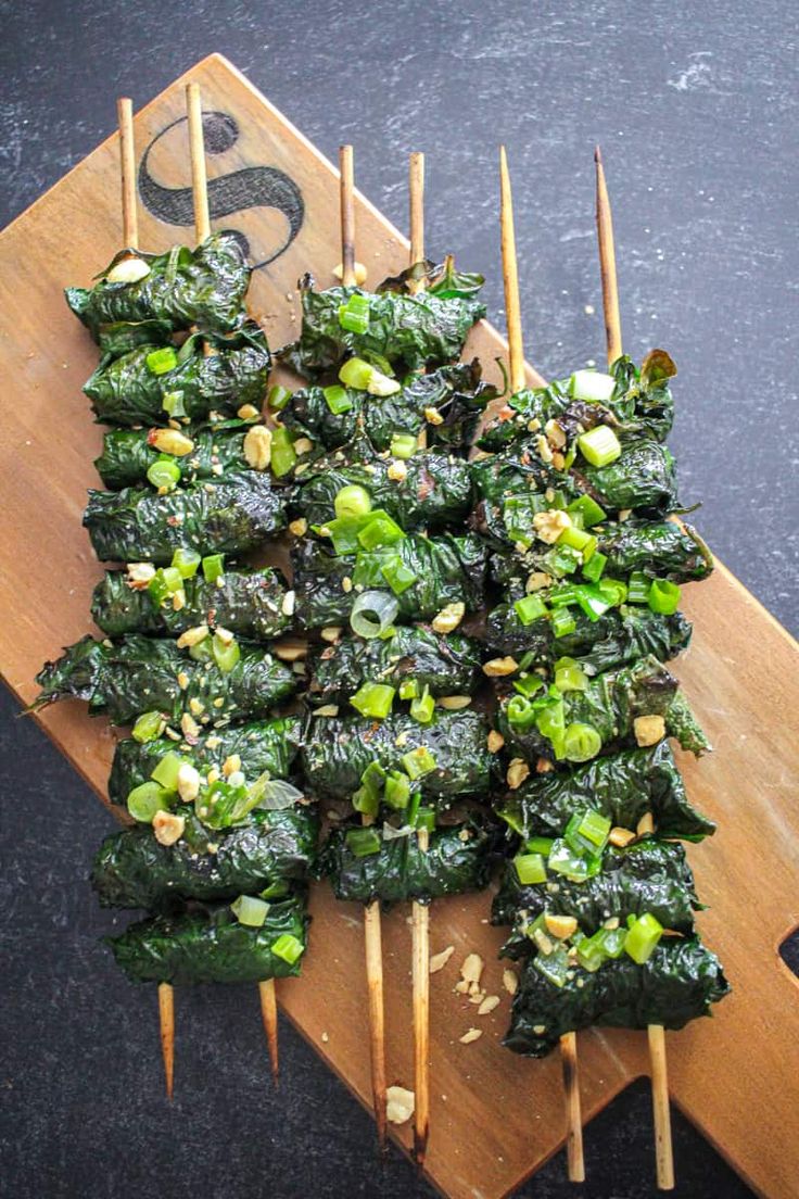 some food is sitting on top of a cutting board with toothpicks sticking out of it