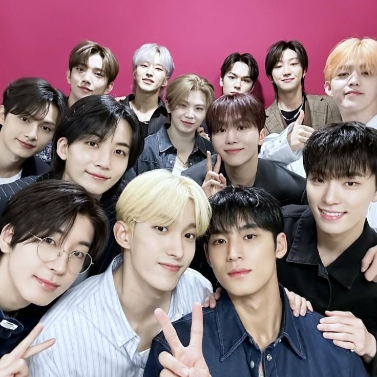 the group of young men are posing together for a photo with their fingers in the air