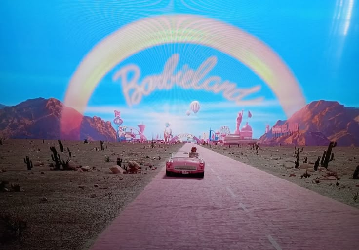 a car driving down a desert road under a rainbow sign