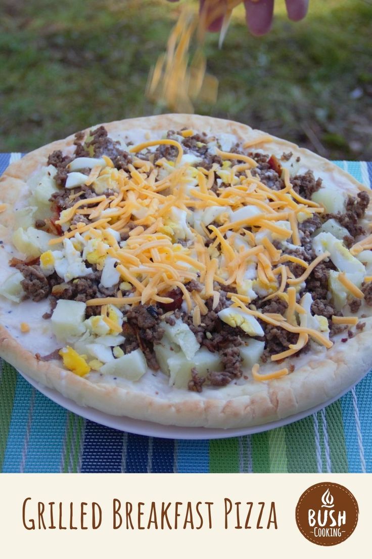 a person is sprinkling cheese on a pizza with meat and potatoes in the foreground