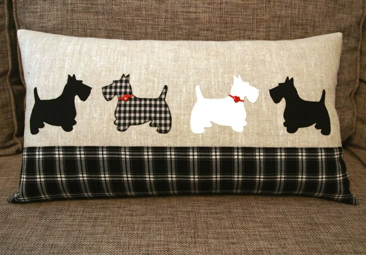 a pillow with three scotties on it sitting on a couch next to a chair