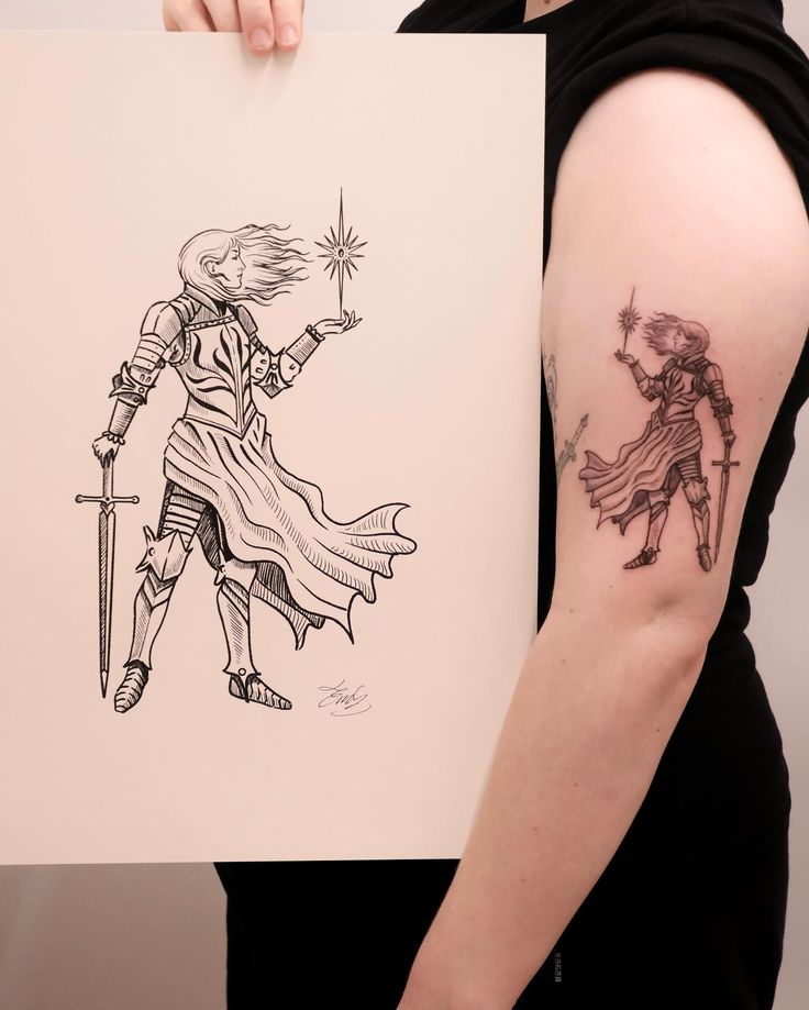 a woman holding up a piece of paper with a drawing of a knight and demon on it