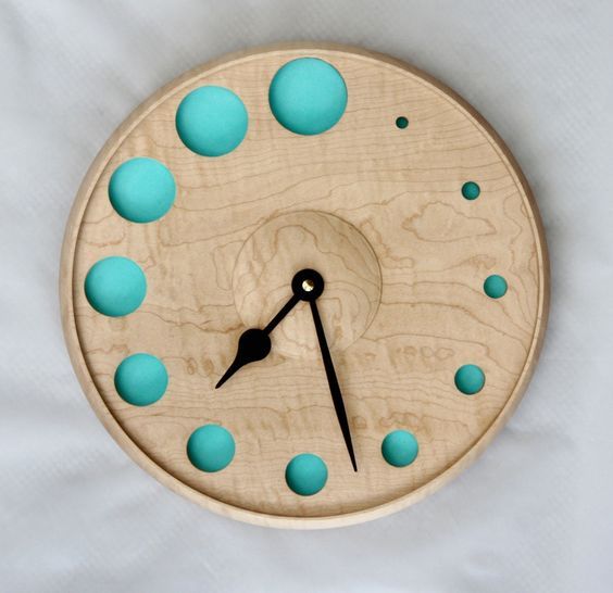 a wooden clock with blue dots on it's face and numbers in the middle