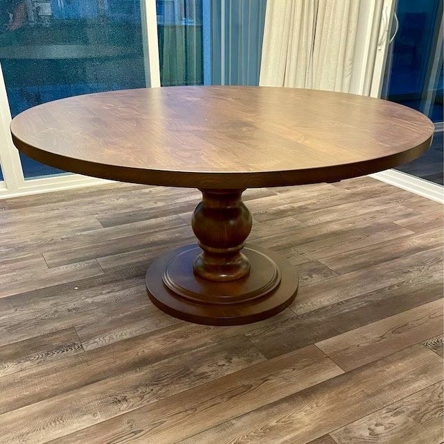 a wooden table sitting on top of a hard wood floor next to a sliding glass door