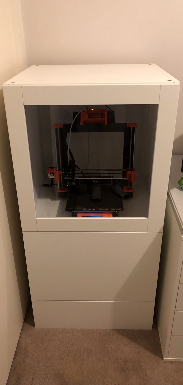 a 3d printer sitting on top of a white cabinet