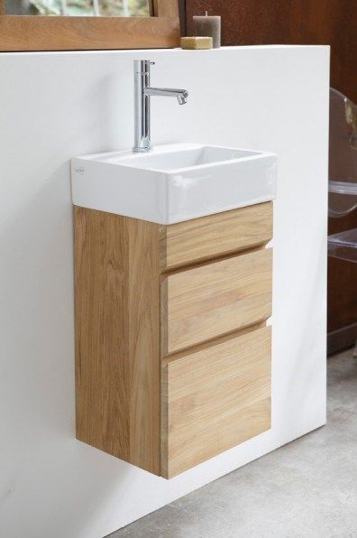 a white sink sitting next to a wooden cabinet