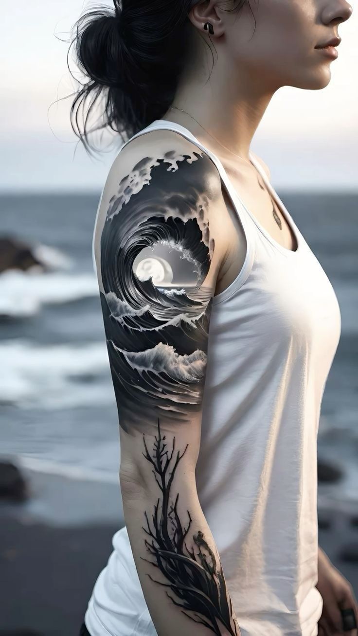 a woman with a wave tattoo on her arm and shoulder, next to the ocean