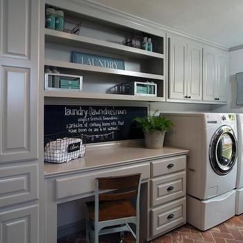 a washer and dryer sitting in a room next to a desk with books on it