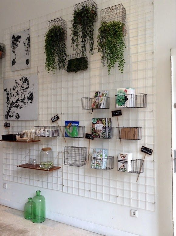 the wall is covered with hanging plants and baskets