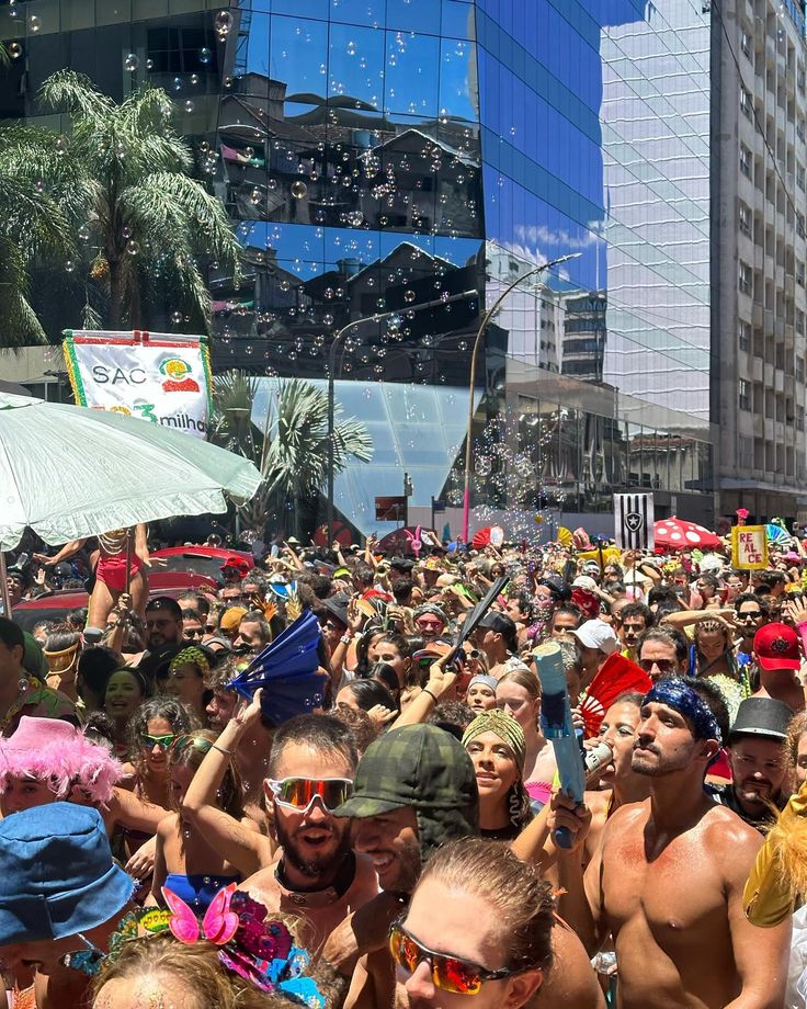 a large group of people standing in the middle of a street with buildings behind them