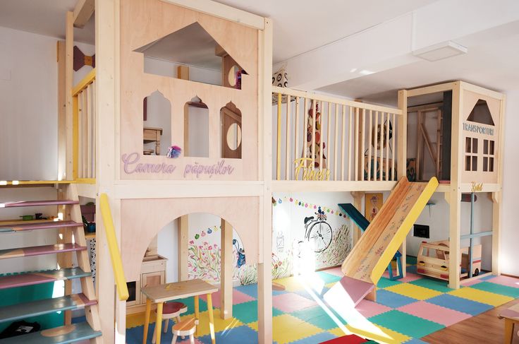 children's play area with slide and climbing wall in residential home setting, including stairs