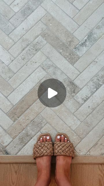 a person standing in front of a tile floor with their feet on the ground,