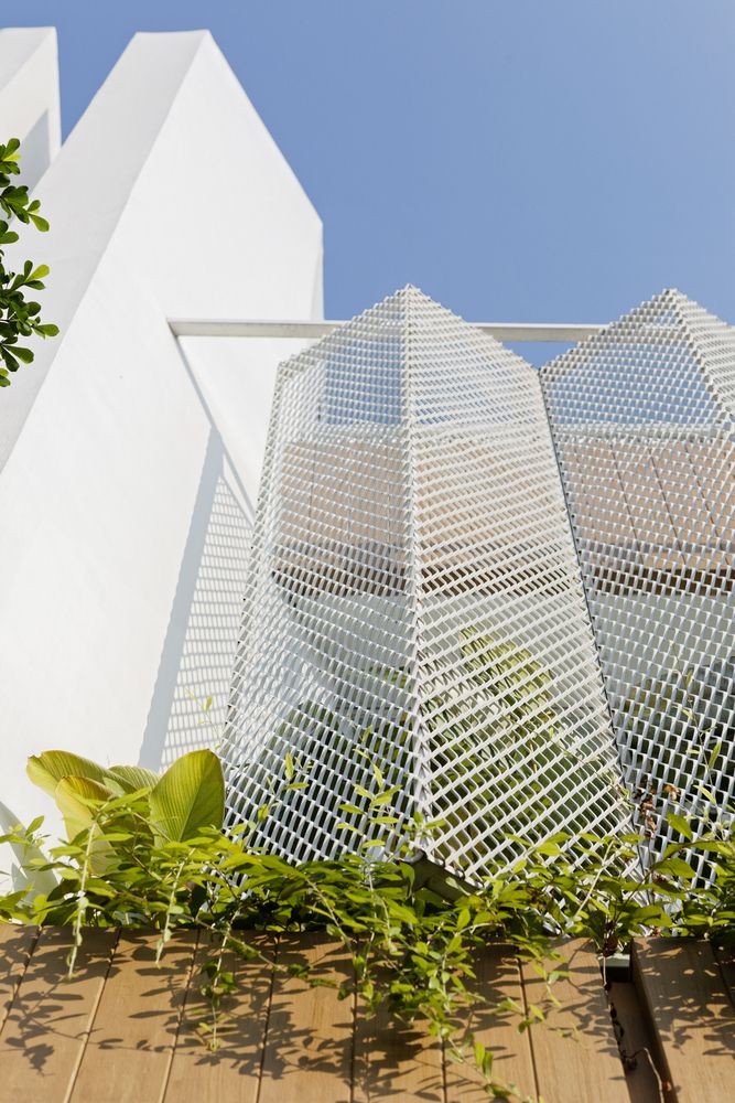 the building is white and has plants growing out of it