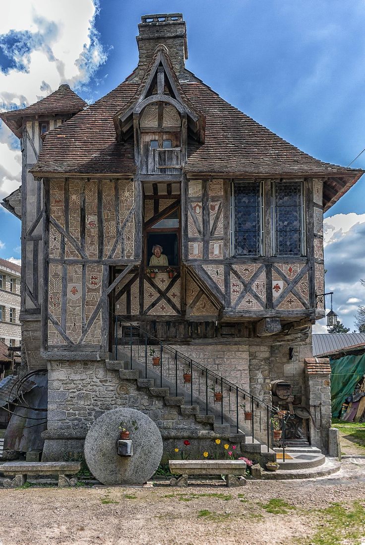 an old style house with stairs leading up to the second floor and windows on each side